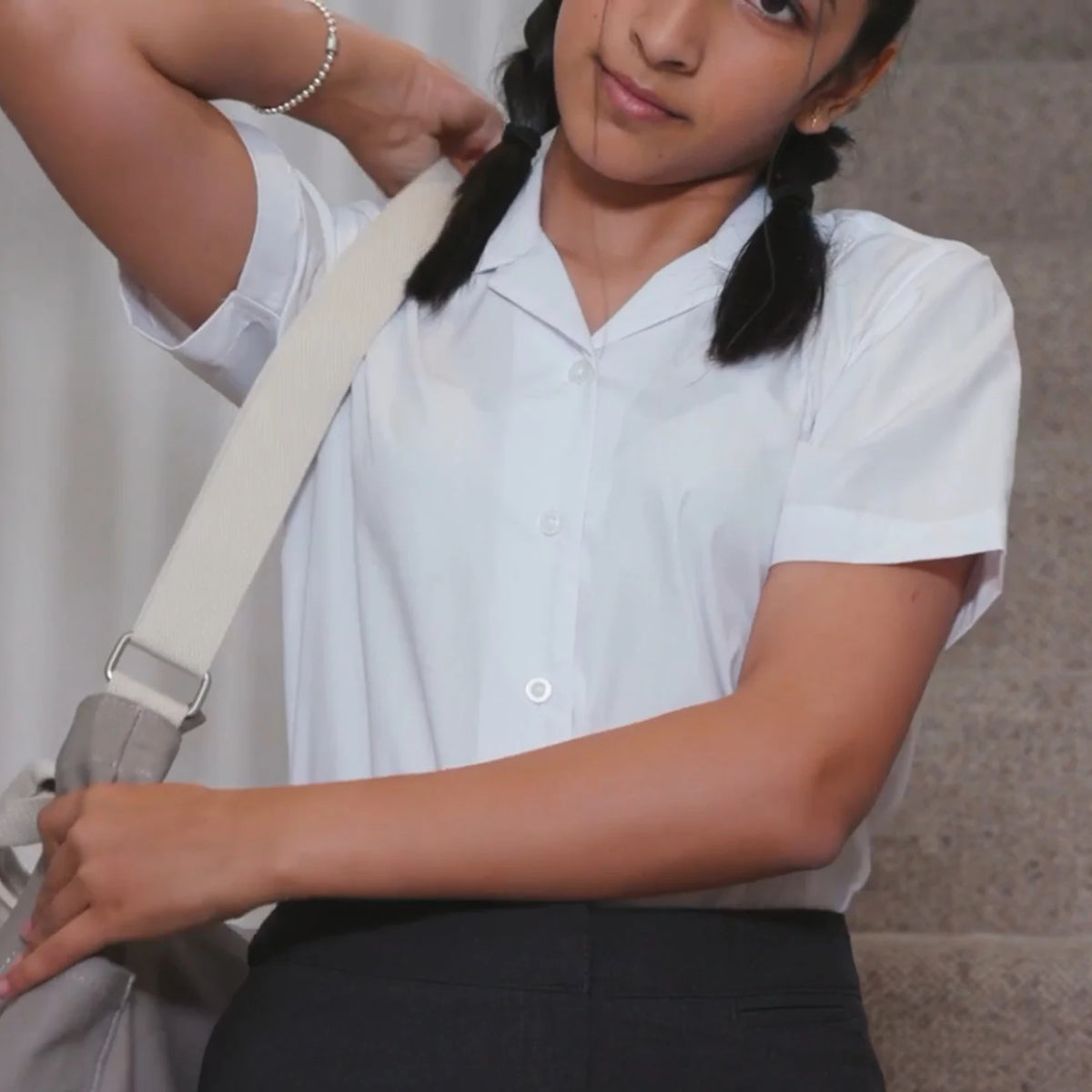 Model wearing the David Luke Schoolwear Girls Eco Short Sleeve Revere Collar School Blouse in White.