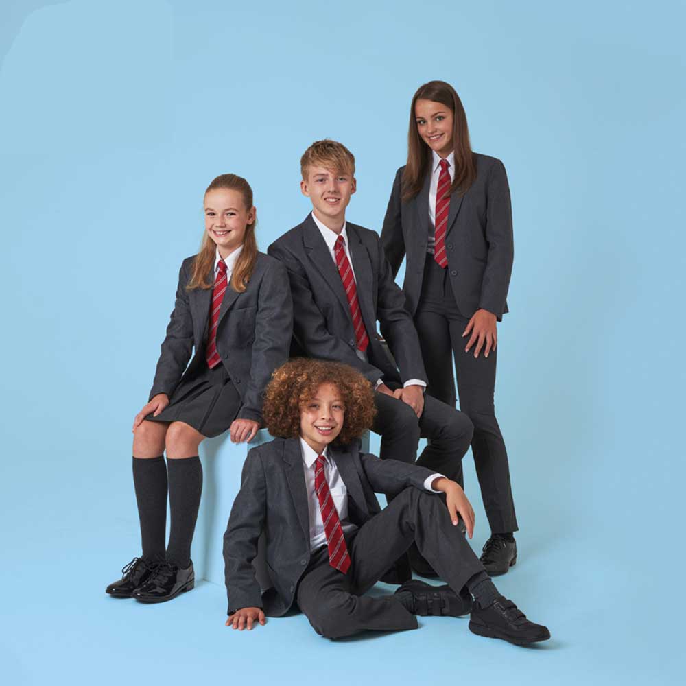 Secondary school children wearing grey school blazers and matching trousers and red ties